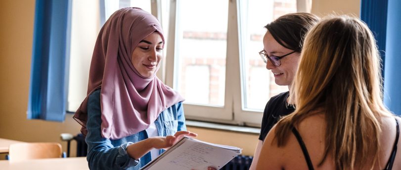 Digitale Bildung und Medienkompetenz an der RSC Schüler nutzt ein Tablet im Unterricht zur Recherche, während die Lehrkraft assistiert.